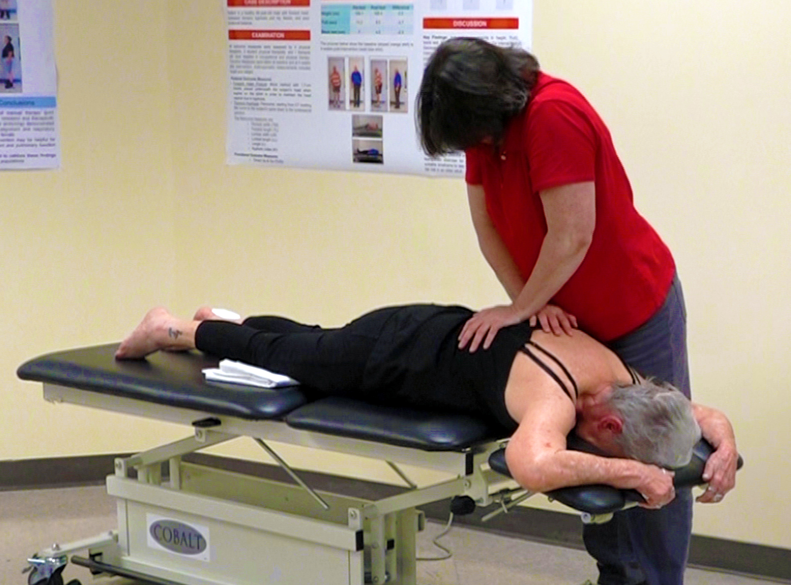 Lynne Hughes applies pressure to a patient's back.